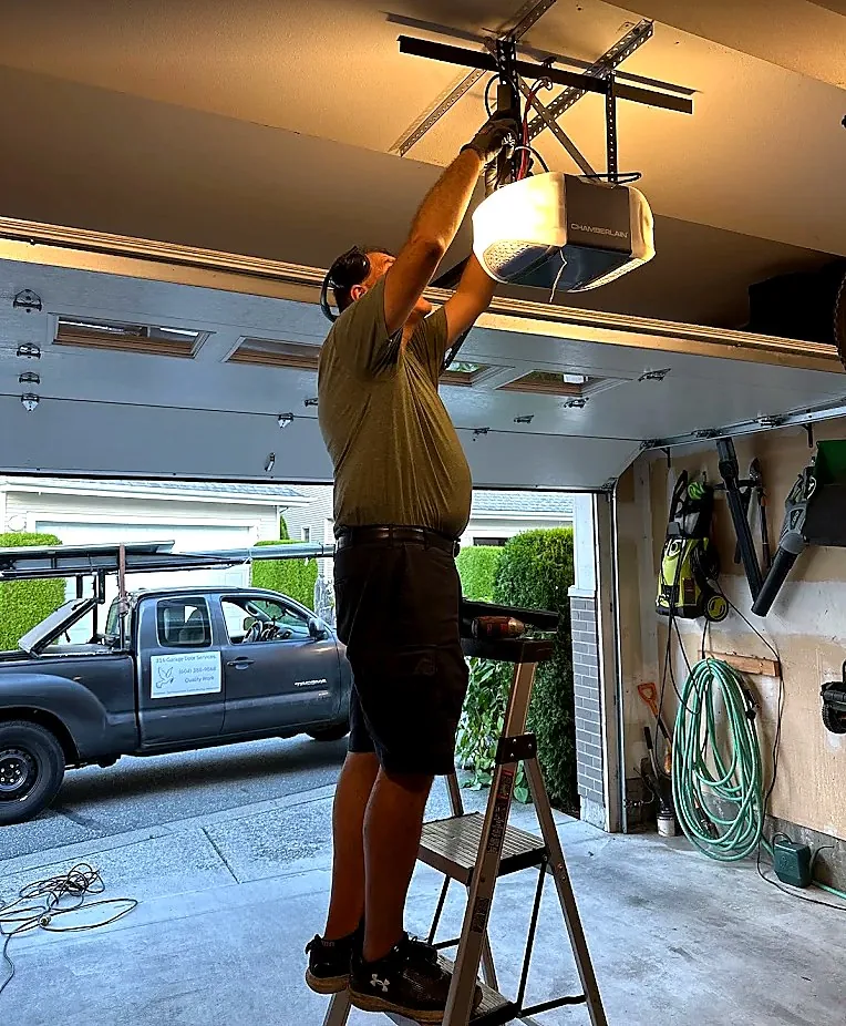 Technician installing a new belt-drive garage door opener